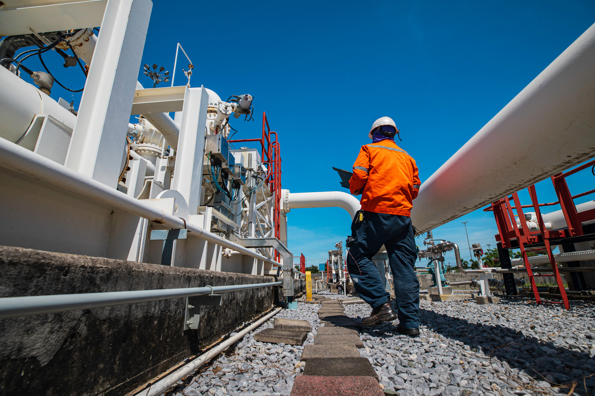 Male worker inspection at steel long pipes and pipe elbow in sta Male worker inspection at steel long pipes and pipe elbow